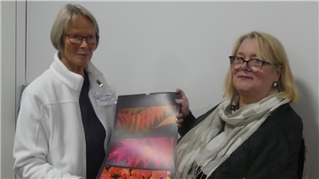 Dorothea Belmer (links) zeigt Kirsten Fischer einen ihrer großformatigen Kalender.