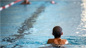 Kind schwimmt im Pool. 