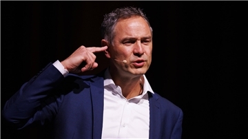 Dr. Daniele Ganser bei seinem Vortrag in der Dortmunder Westfalenhalle im März 2023. Die Stadt musste nach einem Gerichtsurteil den Auftritt zulassen.