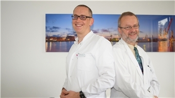 Zwei Männer vor einem Bild von Bremerhaven.