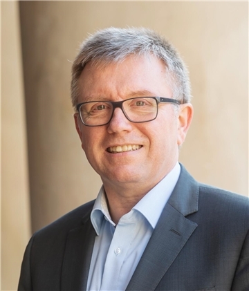 Mann mit grauen Haaren und Brille , lächelt