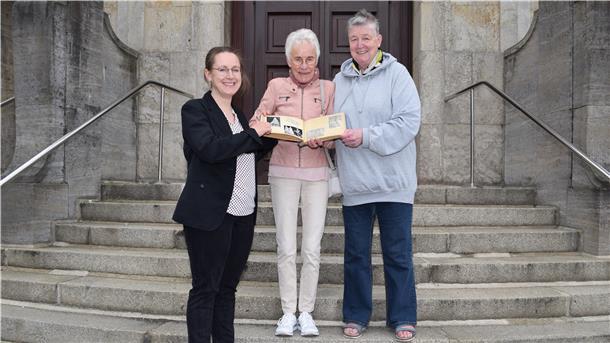 Dr. Julia Kahleys, Leiterin des Stadtarchivs (links), freut sich, dass Heide Lange (Mitte) und Astrid Röhling-Horn ihr das Fan-Album von Jutta Gaudig übergeben.