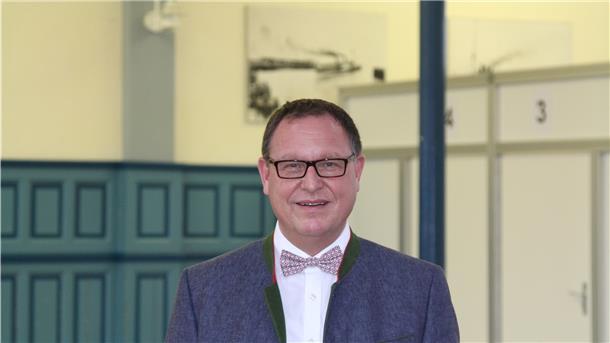 Dr. Pio Faust ist der Ärztliche Leiter des Impfzentrums Cuxhaven in den Hapag-Hallen. Im Hintergrund sind einige der aufgebauten Kabinen zu erkennen. Foto: Reese-Winne