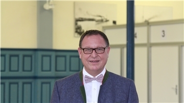 Dr. Pio Faust ist der Ärztliche Leiter des Impfzentrums Cuxhaven in den Hapag-Hallen. Im Hintergrund sind einige der aufgebauten Kabinen zu erkennen. Foto: Reese-Winne