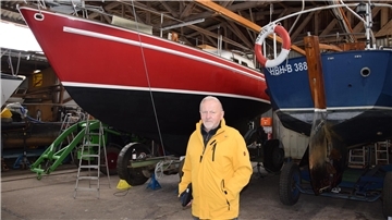 Werner Helle steht vor seinem Segelschiff, die Freya. 