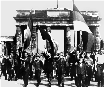 Ost-Berliner marschieren mit wehenden Fahnen vom Ost-Sektor aus durch das Brandenburger Tor. Am 17. Juni 1953 protestierten in der DDR eine Million Menschen gegen den noch jungen sozialistischen Staat - bis sowjetische Panzer den Aufstand beendeten. 