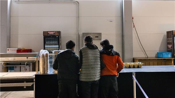 Drei junge Männer im Kantinenbereich einer Notunterkunft in Offenburg.