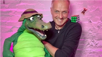 Bauchredner Andreas Römer hält die Puppe eines Krokodils