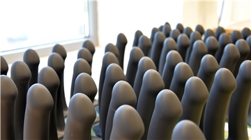 Schwarze Dildos aus Silikon stehen in Reih und Glied.