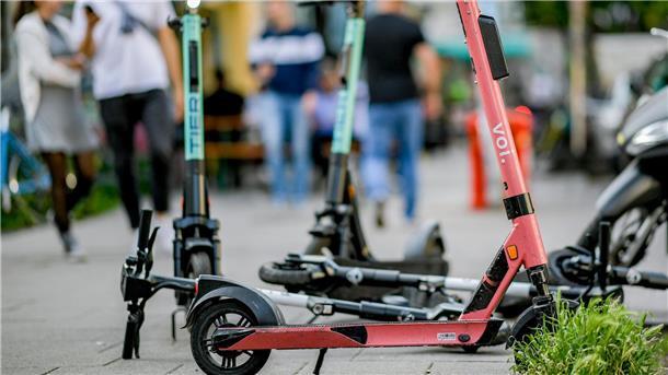 E-Scooter stehen auf einem Gehweg.