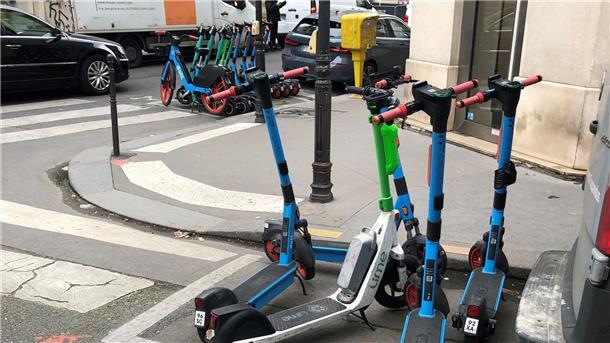 Pariser stimmen über Zukunft der E-Scooter ab E-Scooter von drei verschiedenen Anbietern stehen auf dafür vorgesehenen Parkplätzen.