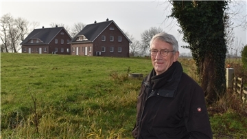 Eckhard Dunkhase am Fuß der Sillenser Dorfwurt. Im Hintergrund sind die beiden neu gebauten Wohnhäuser zu sehen – zwei von insgesamt acht baurechtlich zulässigen