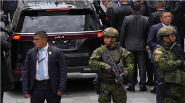 Ecuadors Staatspräsident Guillermo Lasso (M) wird von Sicherheitskräften umgeben, als er in ein Auto steigt.