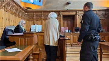 Mann im Gerichtssaal neben einem Justizbeamten. 
