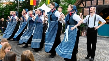 Von Scheeßel in die Welt: Blaudruck-Geschenke beim Beeke Festival Frauen mit blauen Schürzen stehen nebeneinander.