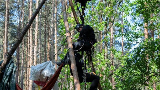 Polizei räumt Protestcamp in Berliner Wuhlheide Ein Aktivist wird von einem Polizeibeamten aus einem Baumhaus in der Wuhlheide geholt.