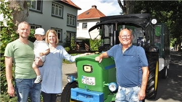 Ein alter Trecker in der Nordenhamer Lutherstraße. Der gehört Manfred Liboschik (rechts). Der hat dort seinen Neffen Thorsten Riekes sowie dessen Frau Theda und Sohn Michel besucht. Drei Tage hat er für die Anfahrt gebraucht.