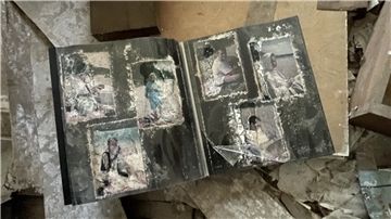 Ein altes Fotoalbum liegt aufgeschlagen auf Sperrmüll