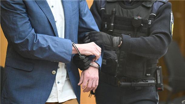 „Reichsbürger“-Prozess gestartet Ein Angeklagter wird bei Prozessbeginn in den Gerichtssaal geführt.