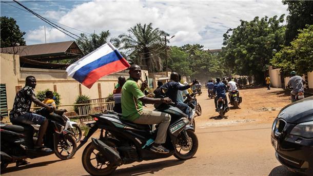 London: Wagner-Armee wird wieder aktiver Ein Anhänger von Hauptmann Traore schwenkt eine russische Fahne auf einem Motorrad.