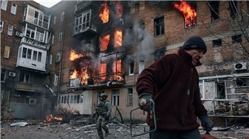 Krieg gegen die Ukraine: So ist die Lage Ein Anwohner verlässt in Bachmut sein Wohnhaus, das nach einem Beschuss in Flammen steht.