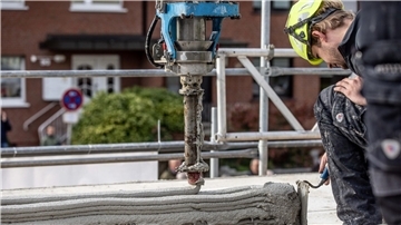 Haus aus dem 3D-Drucker: Neue Wege im Sozialen Wohnungsbau Ein Arbeiter inspiziert die Baustelle eines Mehrfamilienhauses aus dem 3D-Drucker.