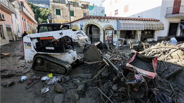 „Eine Tragödie“: Sieben Tote nach Unwettern in Ischia Ein Arbeiter räumt mit einem Bagger eine Straße frei.