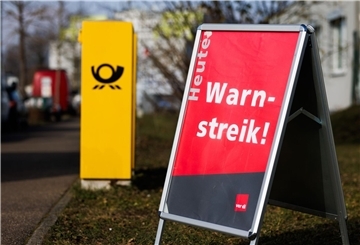 Ein Aufsteller mit der Aufschrift "Heute Warnstreik!" steht neben einem Briefkasten der Deutschen Post. Im Tarifkonflikt bei der Deutschen Post ruft die Gewerkschaft Verdi nun auch in der Paketzustellung zu Warnstreiks auf.