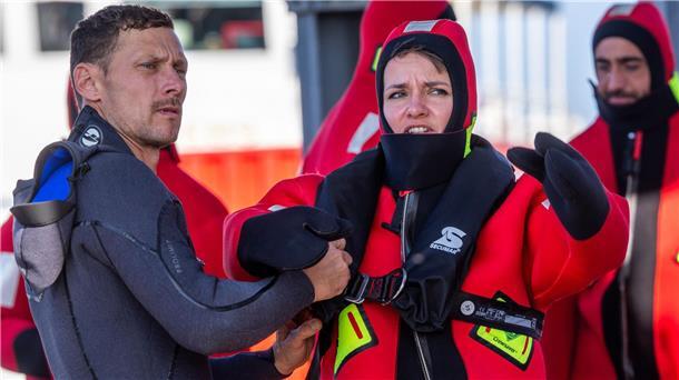 Als Astronautin im Meer überleben Ein Ausbilder hilft Amelie Schönenwald beim Anziehen ihres Überlebensanzugs.