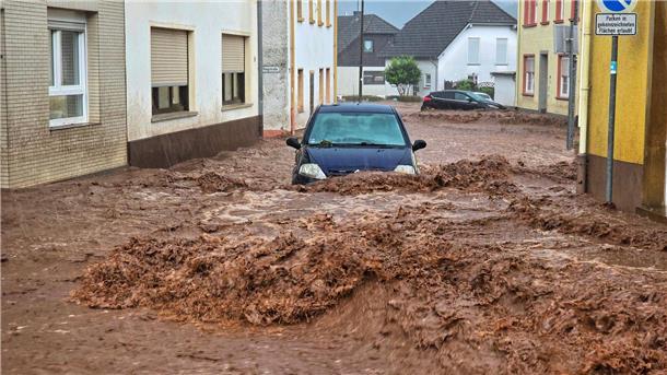 Ein Auto bahnt sich den Weg durch die Wassermassen in Kirn.