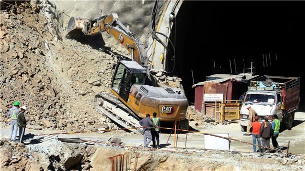 Rennen gegen die Zeit: Tunnel-Drama hält Indien in Atem Ein Bagger arbeitet am Eingang des Straßentunnels, der eingestürzt ist.
