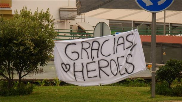 Ein Banner mit der Aufschrift „Gracias, Heroes“ (Danke, Helden) ist an einem Kreisverkehr gespannt.