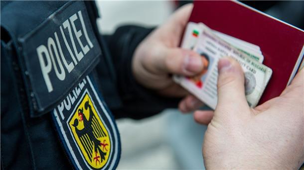 2021 deutlich mehr unerlaubte Migration nach Deutschland Ein Beamter der Bundespolizei hält bei einer Kontrolle ausländische Ausweise in den Händen.