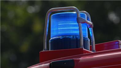 Ein Blaulicht leuchtet auf dem Dach eines Einsatzfahrzeugs der Feuerwehr.