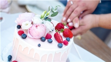 Ein Brautpaar schneidet eine Torte bei einer Hochzeitsfeier an. Im ersten Halbjahr 2022 haben in Niedersachsen wieder mehr Paare geheiratet und es wurden weniger Scheidungsanträge eingereicht als im Vorjahreszeitraum.