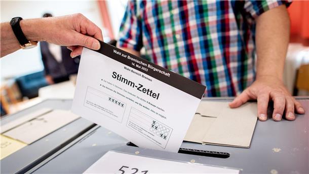 Bremen wählt Landesparlament: Beteiligung etwas niedriger Ein Bürger wirft in einem Wahllokal in eine Wahlurne.
