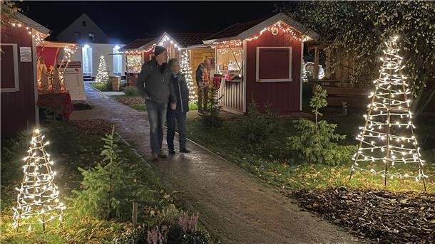Ein Paar bummelt durch das Weihnachtsdorf in Abbehausen.