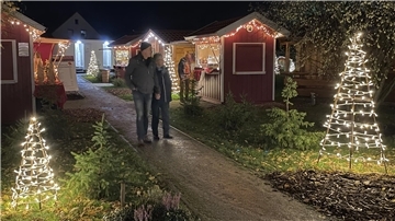 Ein Paar bummelt durch das Weihnachtsdorf in Abbehausen.