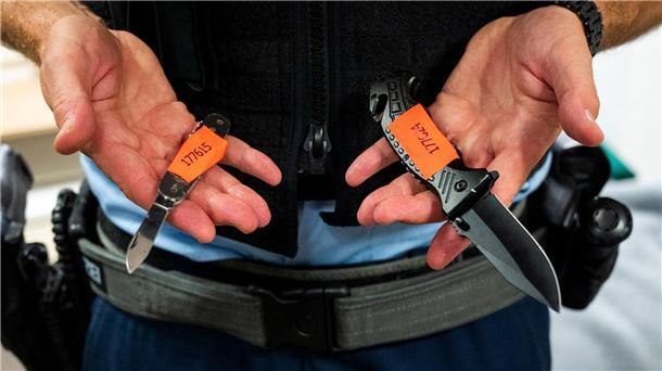 Bremen will Waffenverbotszonen ausweiten Ein Bundespolizist zeigt sichergestellte Messer.