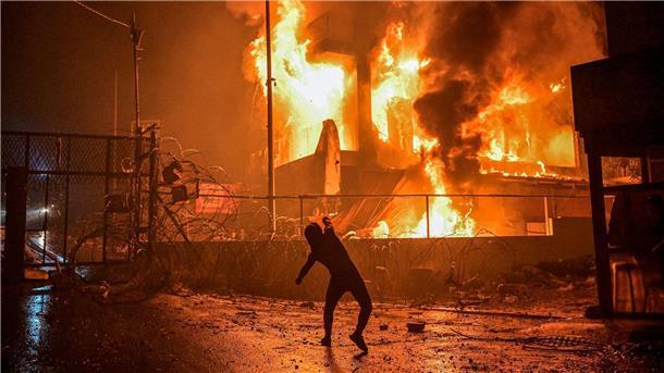Ein Demonstrant wirft nach dem Angriff auf das Krankenhaus im Gazastreifen Steine auf ein brennendes Gebäude in der Nähe der US-Botschaft in Beirut.
