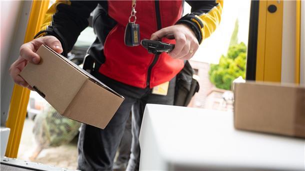 Auch Onlinehandel leidet unter Konsumflaute Ein DHL-Mitarbeiter scant ein Paket für die Zustellung.
