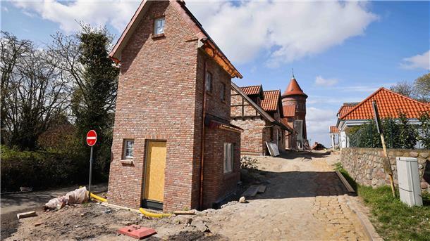 Ein ehemaliges Trafohäuschen (l) und weitere restaurierte oder im historischen Stil gebaute Hotel-Häuschen stehen neben dem Wasserturm am Kalkberg.