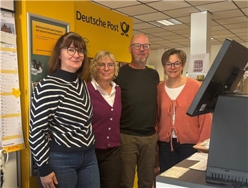 Drei Frauen und ein Mann blicken in die Kamera.