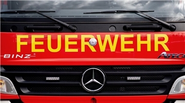 Ein Einsatzfahrzeug der Feuerwehr steht  auf einem Parkplatz.