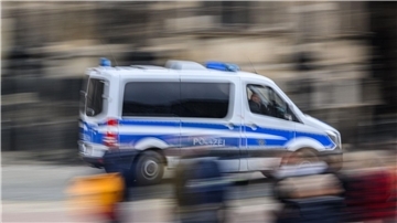 Ein Einsatzwagen der Polizei fährt durch eine Stadt.