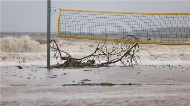 Schwere Sturmflut setzt der Ostsee-Küste zu - Eine Tote Ein entwurzelter Baum liegt unter einem Volleyballnetz am Ostseestrand von Eckernförde.