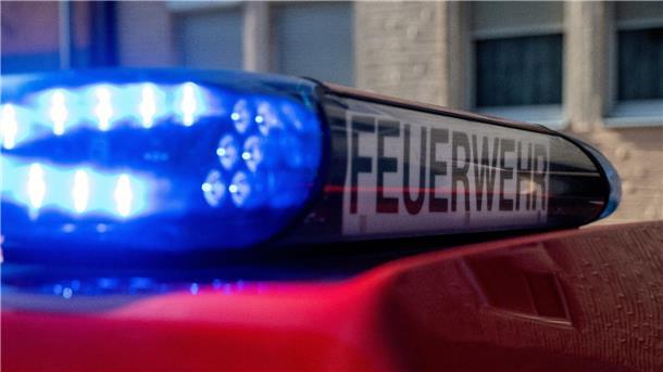 Ein Fahrzeug der Feuerwehr steht mit eingeschaltetem Blaulicht an einem Einsatzort.