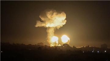 Ein Feuerball und eine Rauchwolke steigen während eines Luftangriffs über Gebäuden auf.