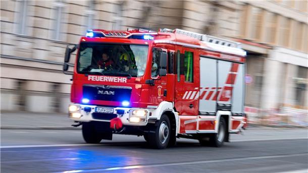 Ein Feuerwehrfahrzeug ist mit Blaulicht auf Einsatzfahrt.