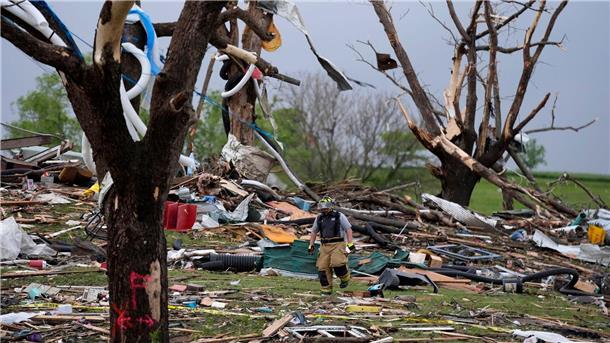 Tote und Schäden nach Tornados in den USA Ein Feuerwehrmann geht in Greenfield, Iowa, zwischen von einem Tornado zerstörten Häusern umher.